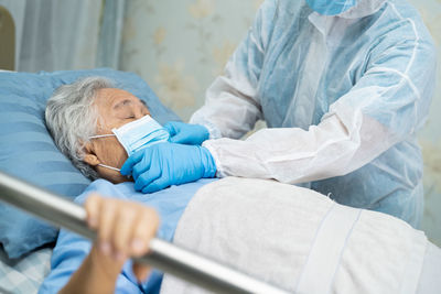 Midsection of doctor examining senior patient at hospital