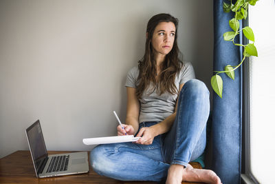 Lonely individual woman on her laptop working / studying at home