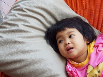 High angle view of cute girl lying on bed at home