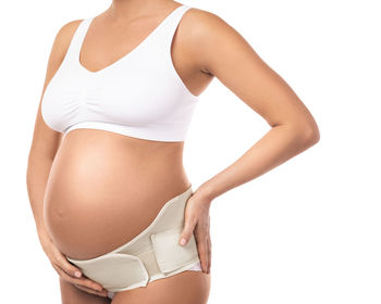 Midsection of woman standing against white background