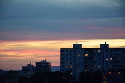 Buildings against dramatic sky during sunset