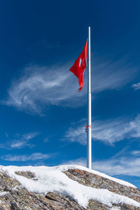 The flag of switzerland on a flagpole in diablerets glacier 3000 in switzerland