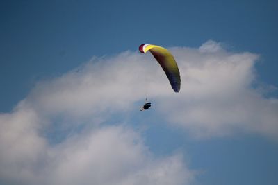 Low angle view of paragliding against sky