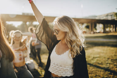 Young woman with arms raised in the background