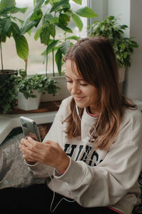 A young pretty woman in headphones communicates via video chat with mobile phone. high quality photo