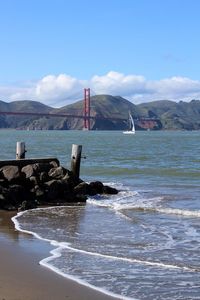 Suspension bridge over sea against sky