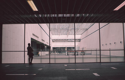 Rear view of silhouette man standing in corridor