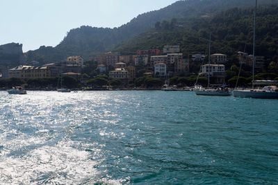 Sea by buildings against sky