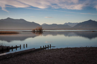 Scenic view of lake chiemsee by mountains against sky