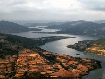High angle view of river amidst mountains against sky