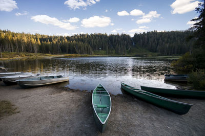 Boats moored in water against sky