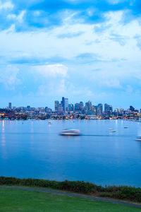 Sea and buildings in city against sky