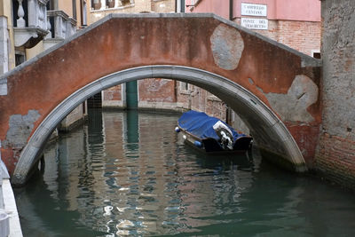 Arch bridge over canal amidst buildings