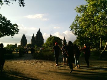 People walking in temple against sky