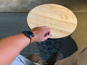 Low section of man holding paper