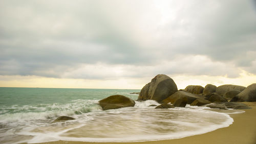 Rocks on beach against sky