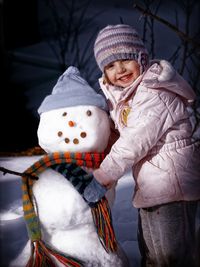 Portrait of girl standing on snow covered landscape