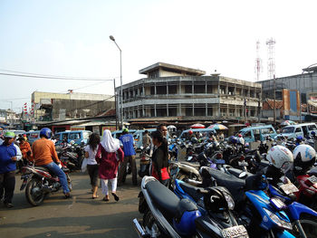 Crowd on street in city against sky