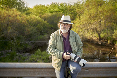 Portrait of young man standing on footbridge