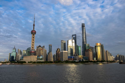 Modern buildings in city against cloudy sky