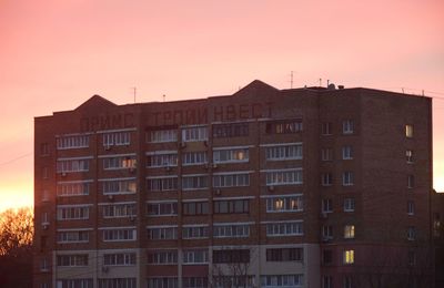 Residential buildings against sky at sunset