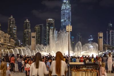 People at illuminated city at night