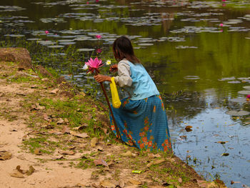 Rear view of woman with flowers in water