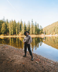 Full length of man standing by lake against sky