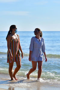 Woman standing on beach against sea