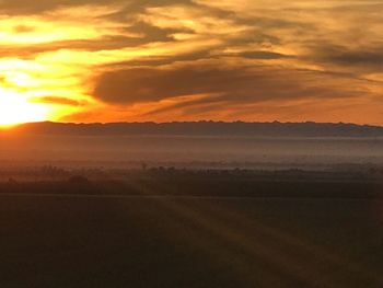 Scenic view of field against sky during sunset