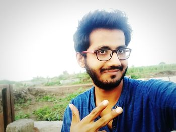 Portrait of young man against sky