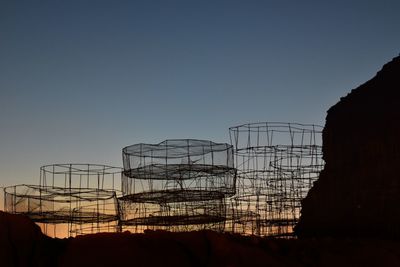 Silhouette of electricity pylon against clear sky