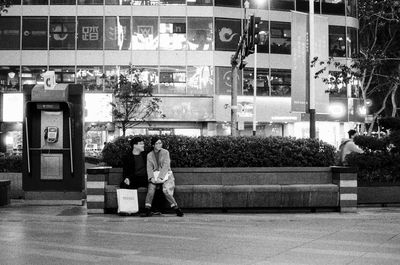 Full length of people on street against building at night