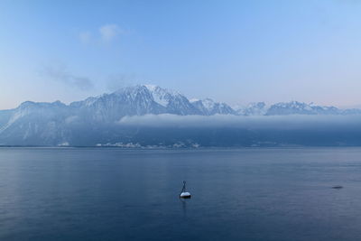 Scenic view of lake geneva and snowcapped mountains against sky
