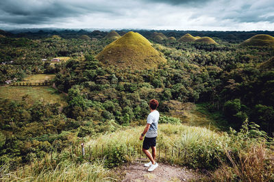 Rear view of man on mountain against sky