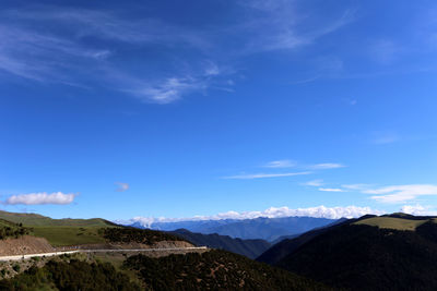 Scenic view of mountains against blue sky