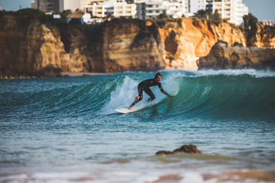 Man surfing in sea against sky