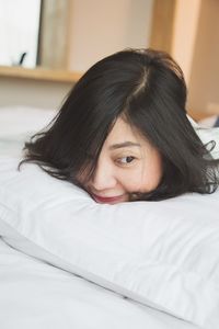 Close-up of woman lying on bed at home