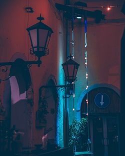 Low angle view of illuminated street light against building at night