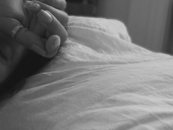 Close-up of woman hand on bed