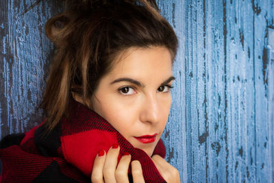 Portrait of beautiful woman against blue wooden fence