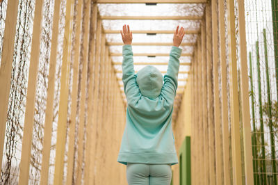 Rear view of woman with arms raised