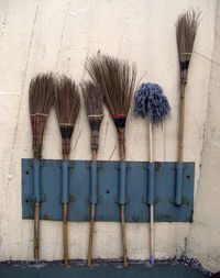 Brooms on rack against wall