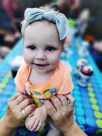 Close-up portrait of cute baby boy holding leaf