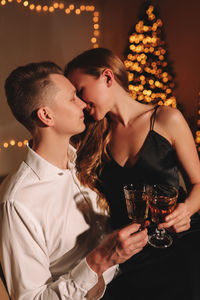 A romantic couple in love celebrates christmas holidays and new year in a cozy house at night