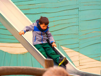 Cute boy playing on slide