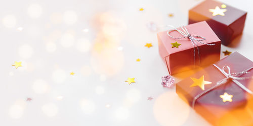 Holiday presents. gifts wrapped in pale pink paper with silver ribbons. stars confetti, copy space.