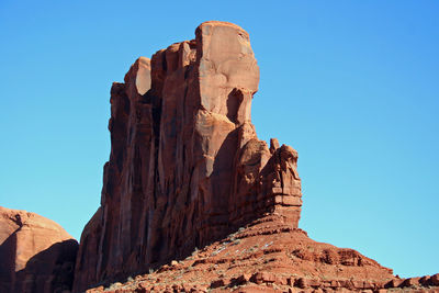 Low angle view of rock formation against clear blue sky