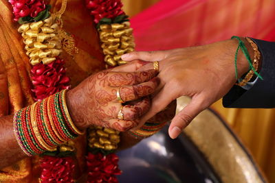 Midsection of bride wearing ring to groom