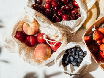 Fresh berries in bags and box on the table in sunlight. purchases made at the local store on  table